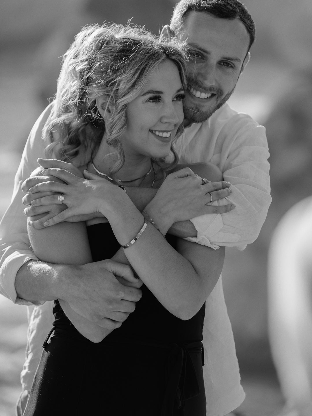 Couple embracing on the cliffs of southern Portugal after a surprise engagement 