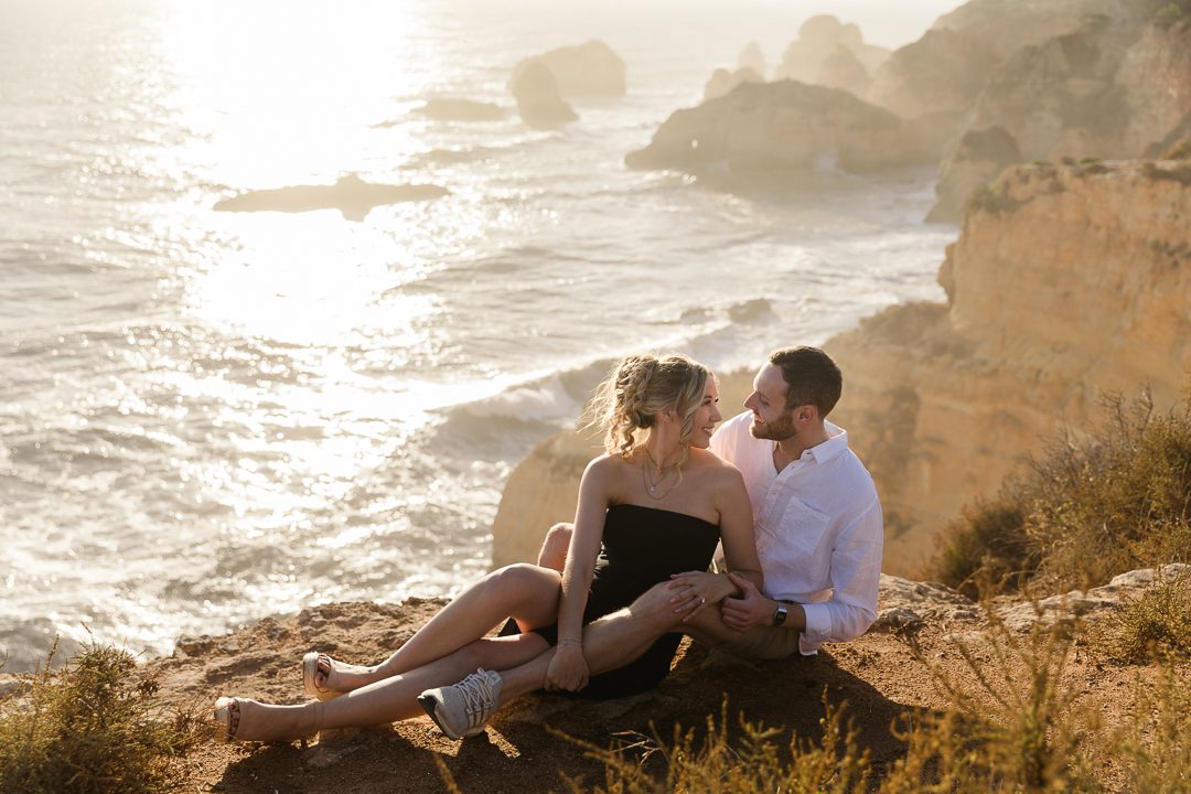 Romantic engagement photos on an Algarve beach with natural light and ocean views 