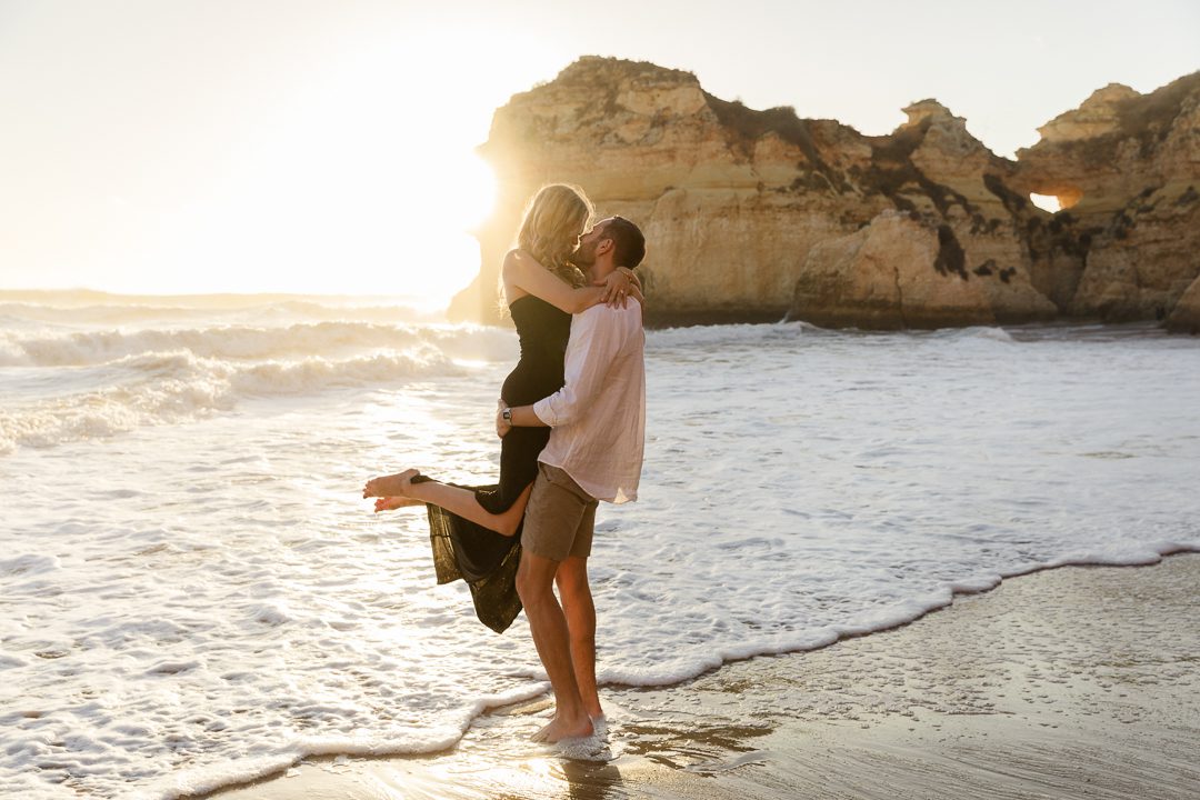 Romantic engagement photos on an Algarve beach with natural light and ocean views 