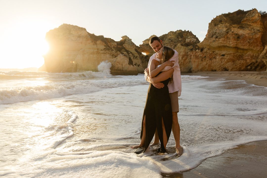 Couple walking barefoot on the beach during an Algarve engagement photography session 