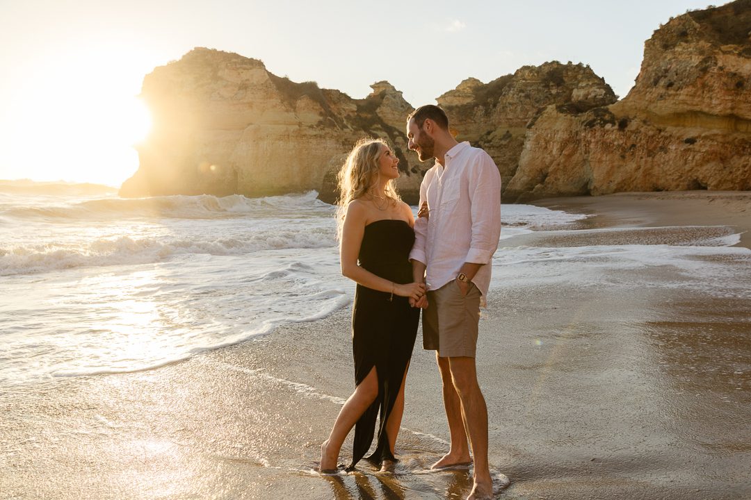 Couple walking barefoot on the beach during an Algarve engagement photography session 