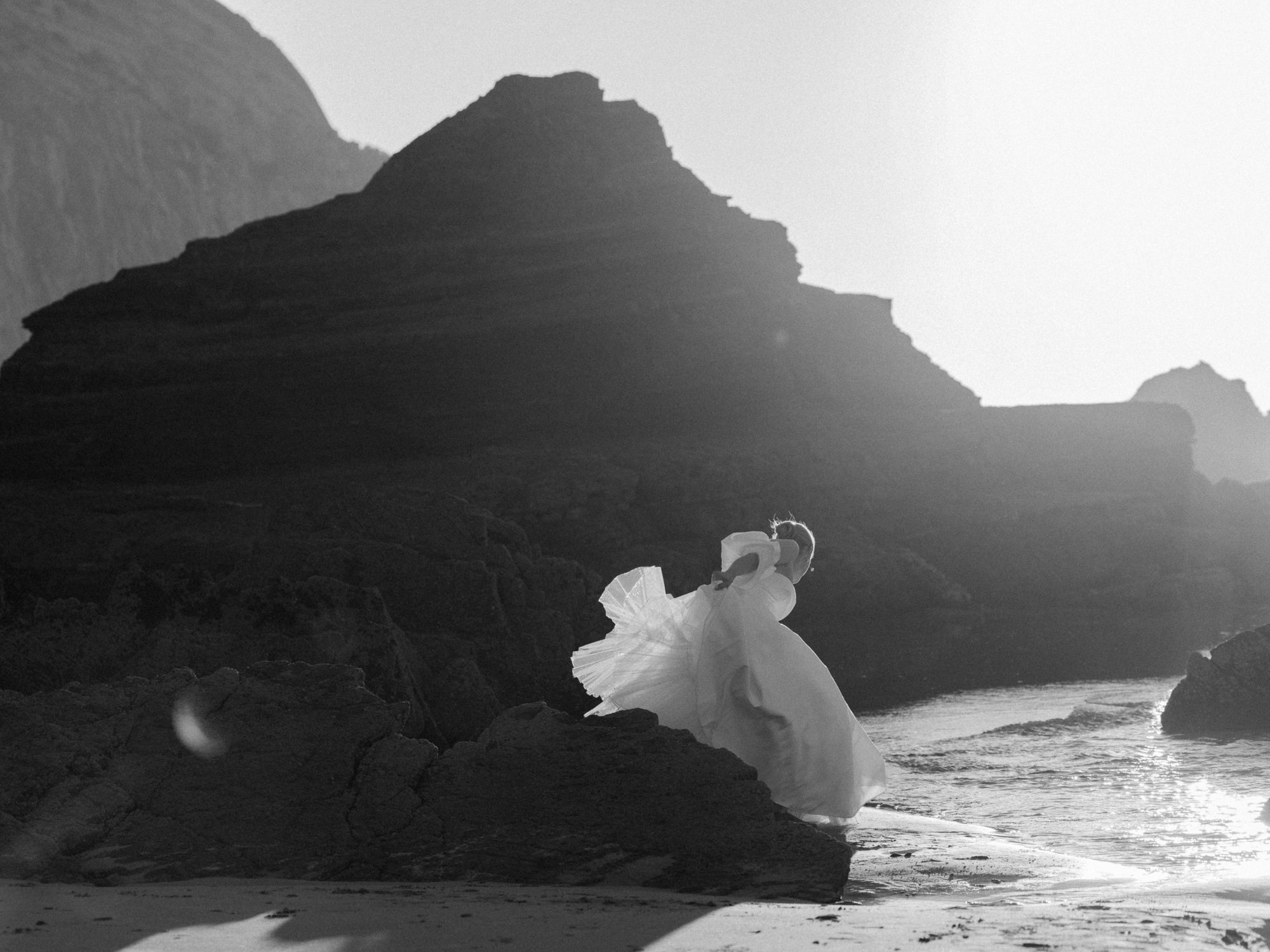 legant bride in a flowing wedding gown against the Algarve coastline
