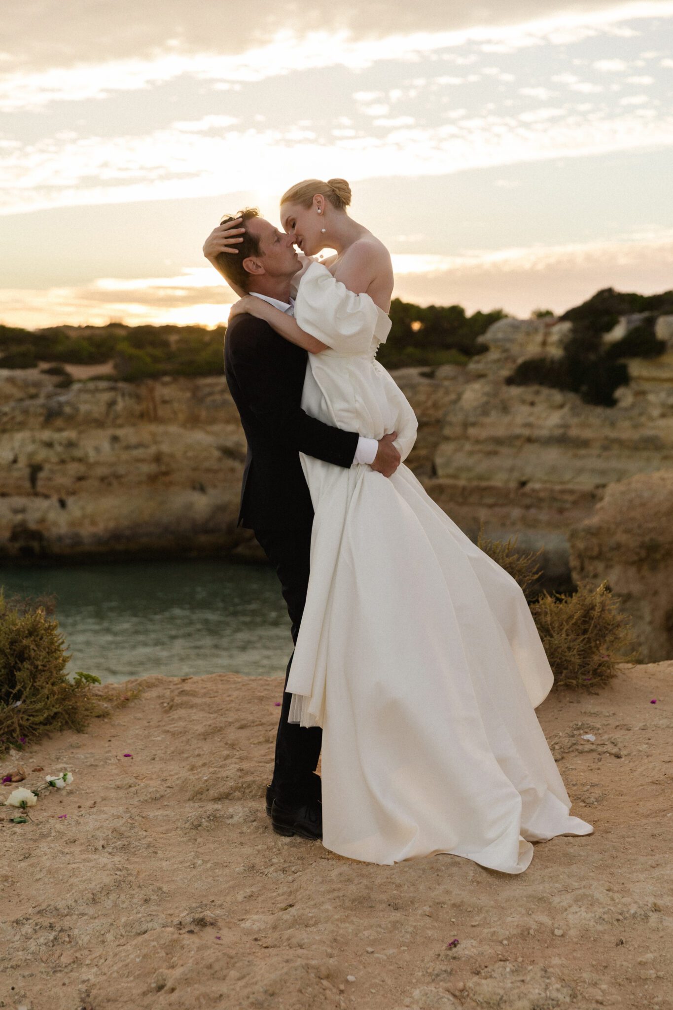 Elegant bride in a flowing wedding gown against the Algarve coastline
